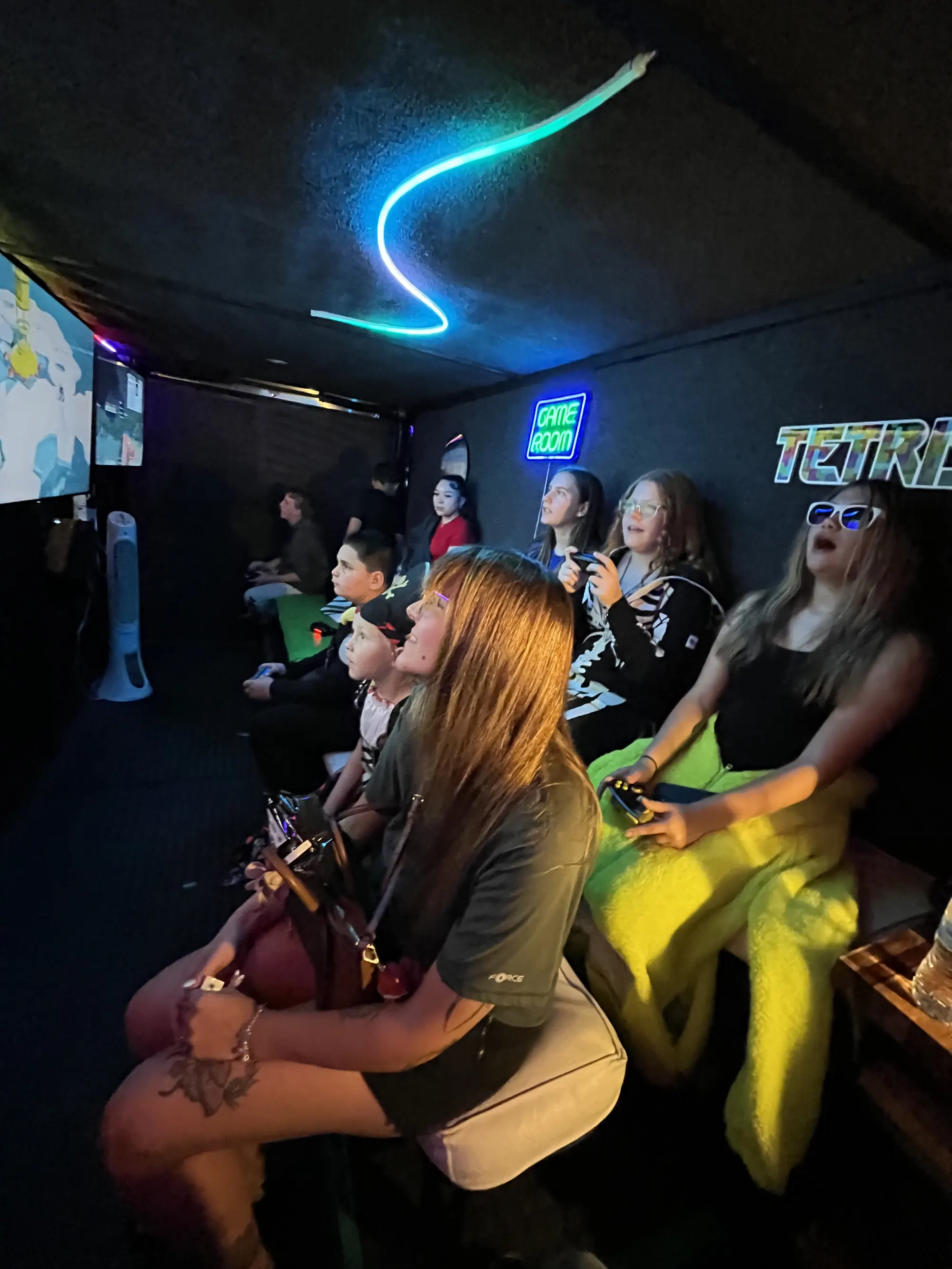 Friends enjoying an evening of gaming under colorful lights