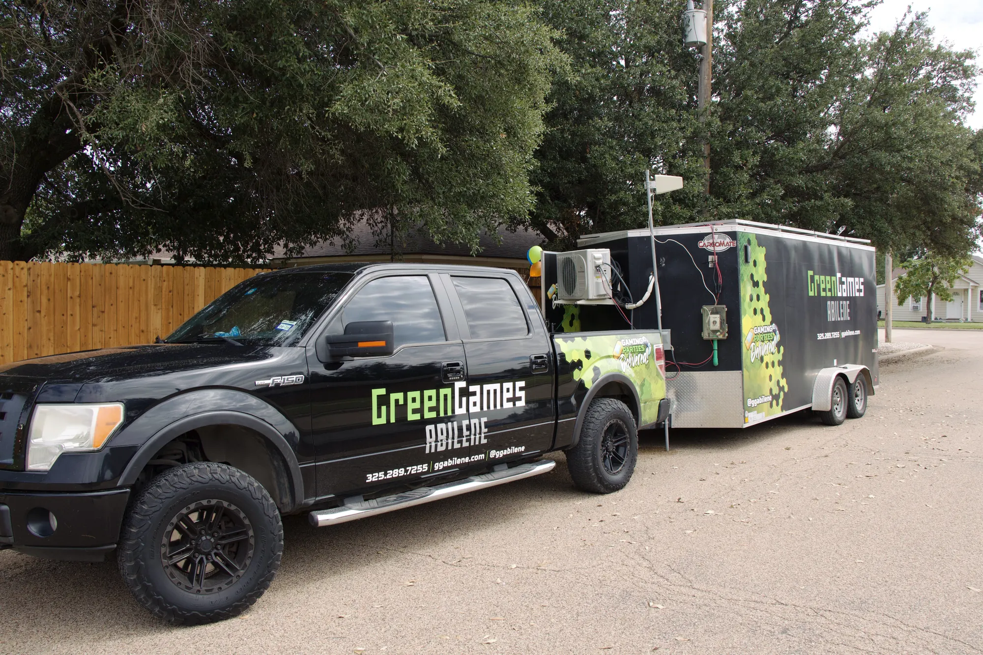 The Green Games truck and solar-powered gaming trailer parked at a party on a sunny day