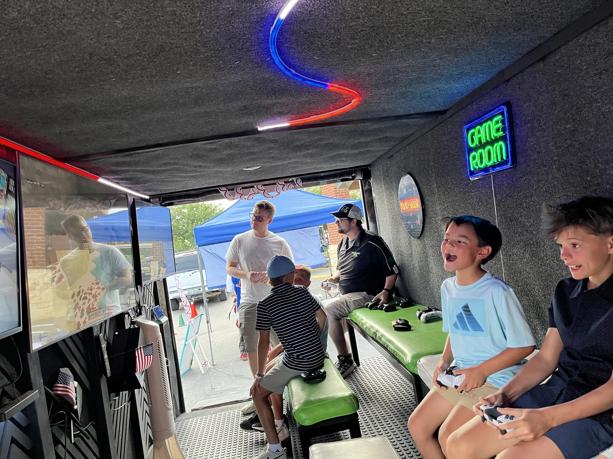 Friends laughing and playing video games together inside the trailer